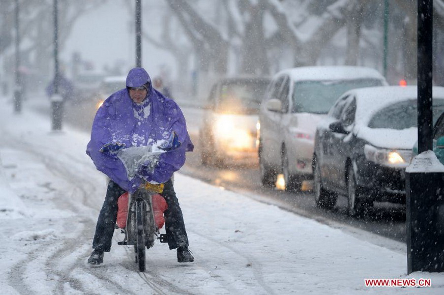 A citizen travels against the snow along a street in Hangzhou, capital of east China's Zhejiang Province, Jan. 4, 2013. Many areas in Zhejiang received snowfalls on Friday. The local meteorological authority issued an orange alert for icy roads on Friday morning, warning the possible disruption which the continued snow might cause to traffic, power supply and agriculture. (Xinhua/Ju Huanzong)