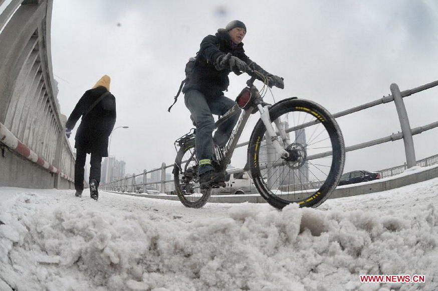 Citizens make their way on a snow-affected road in Changsha, central China's Hunan Province, Jan. 4, 2013. Changsha witnessed this winter's heaviest snowfall on Friday. The snow has caused disruption in the city's urban traffic. (Xinhua/Long Hongtao)