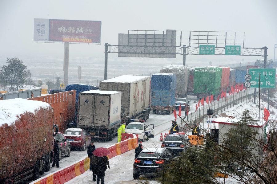 Trucks are stranded on the Nanchang-Zhangshu section of the Shanghai-Kunming highway in east China's Jiangxi Province, Jan. 4, 2013. Vehicles were blocked in a traffic jam on the highway for a couple of hours due to a heavy snowfall in Jiangxi on Friday. (Xinhua/Zhou Ke)