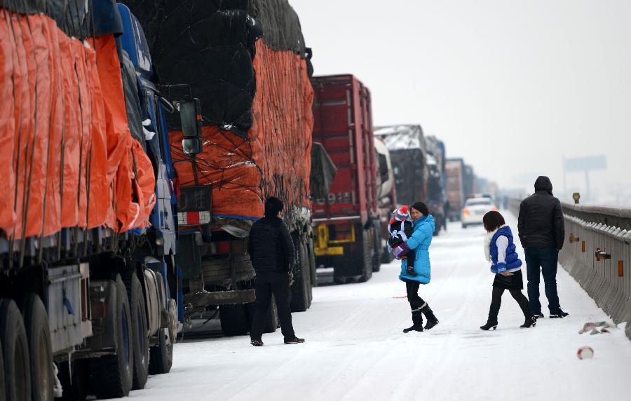 Trucks are stranded on the Nanchang-Zhangshu section of the Shanghai-Kunming highway in east China's Jiangxi Province, Jan. 4, 2013. Vehicles were blocked in a traffic jam on the highway for a couple of hours due to a heavy snowfall in Jiangxi on Friday. (Xinhua/Zhou Ke)