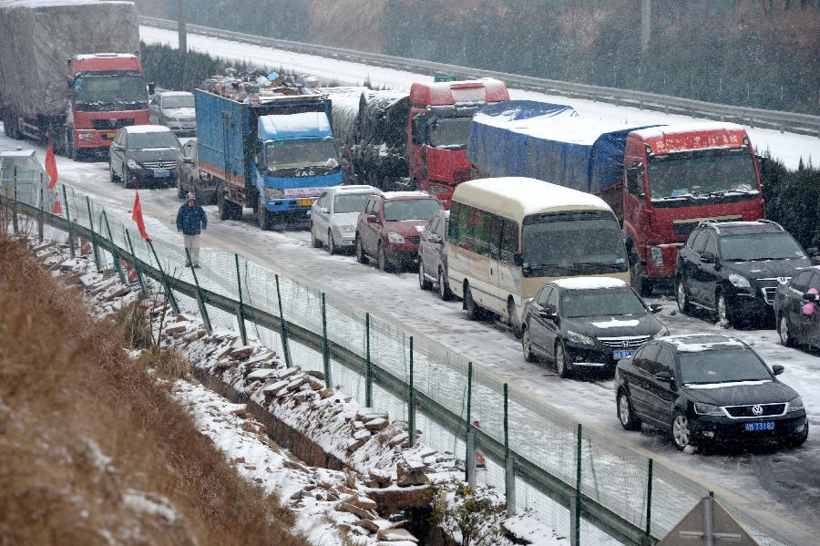 Vehicles line up at the Changzhang section of the Shanghai-Kunming expressway in Nanchang, capital of east China's Jiangxi Province, Jan. 4, 2013. The snowfall which hit most areas of Jiangxi on Friday disrupted expressway traffic, causing several car accidents. (Xinhua/Zhou Ke)