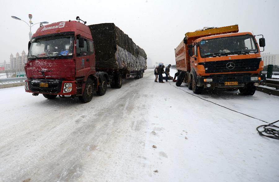 Vehicles run slowly on an icy road in Nanchang, capital of east China's Jiangxi Province, Jan. 4, 2013. Most highways in Jiangxi were frozen and some blocked due to the heavy snow since Thursday night. The provincial meteorological observatory issued an orange alert on icy road on Friday. (Xinhua/Zhou Ke)