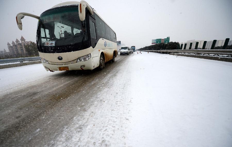 Vehicles run slowly on an icy road in Nanchang, capital of east China's Jiangxi Province, Jan. 4, 2013. Most highways in Jiangxi were frozen and some blocked due to the heavy snow since Thursday night. The provincial meteorological observatory issued an orange alert on icy road on Friday. (Xinhua/Zhou Ke)