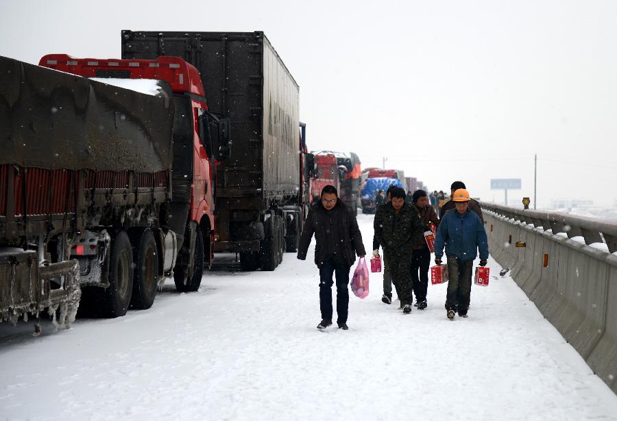 Vehicles line up at the Changzhang section of the Shanghai-Kunming expressway in Nanchang, capital of east China's Jiangxi Province, Jan. 4, 2013. The snowfall which hit most areas of Jiangxi on Friday disrupted expressway traffic, causing several car accidents. (Xinhua/Zhou Ke)