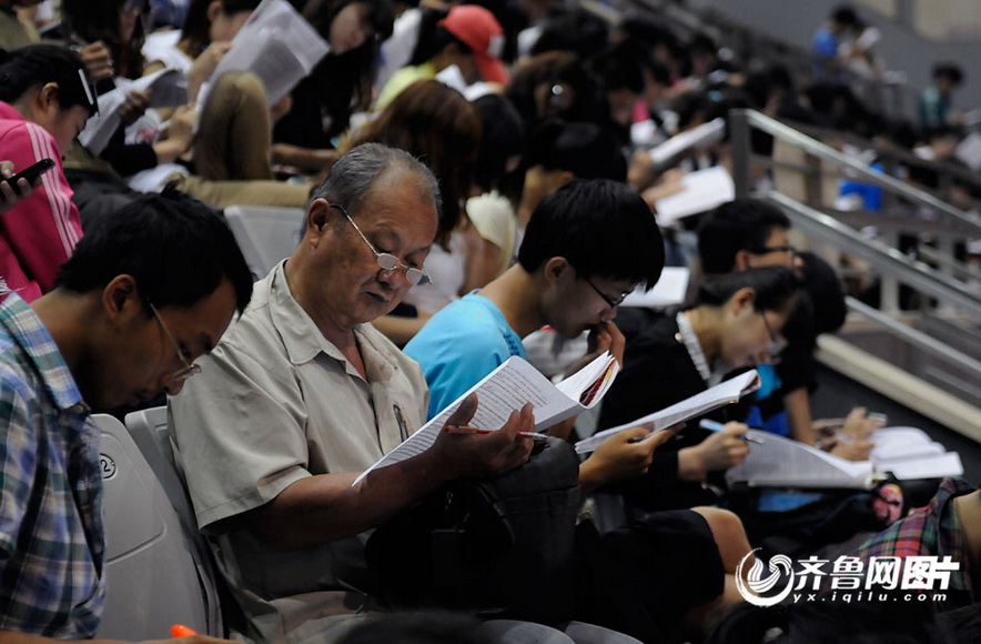 Zhang Shanxue sits in the classroom for exam preparation with young students in summer of 2012.  (Photo/yx.iqilu.com)