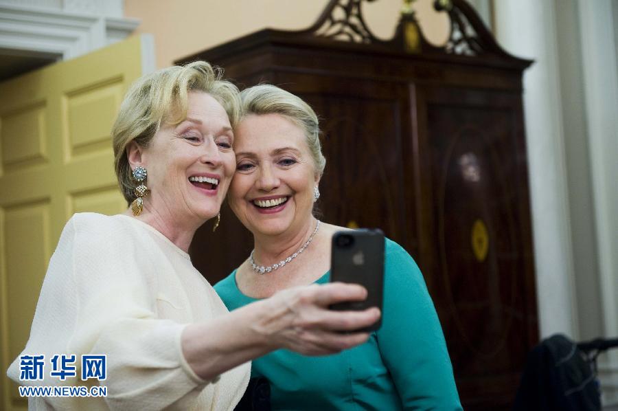 On Dec. 1, famous American actor Merrill Streep (left) and Hillary Clinton, U.S. Secretary of State take photos with mobile phone together in the Kennedy center in Washington, U.S. （Xinhua Photo）