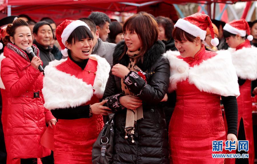 Salespersons wearing Santa Claus costume warmly invite potential buyers to real estate sale department. More than 10 salespersons dressed up as Santa Claus to attract buyers’ attentions in a ceremony of building opening quotation.  (Xinhua/Wang Zirui) 