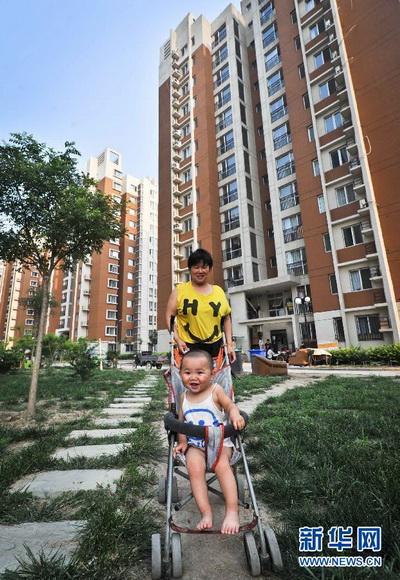 China started construction of 7.22 million units of houses for low-income families with the investment of 1,080 billion yuan in 2012. More low-income families will get benefits from the project. A resident with her kid walks in the residential area of public-rent houses in Tianjin on July 17, 2012. (Xinhua/ Yue Yuewei)