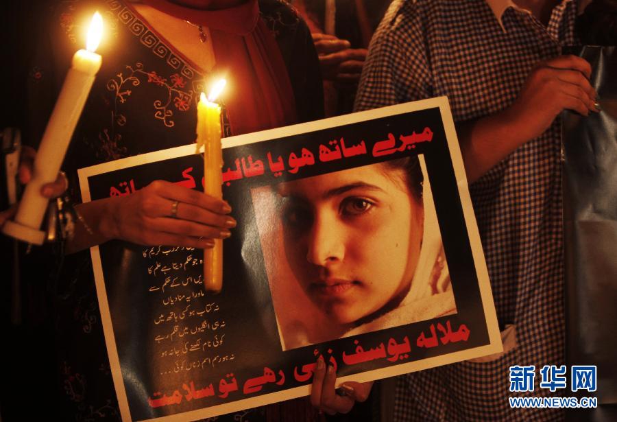 A Pakistani protester holds a candle and a poster that reads “Are you with us or the Taliban? Long live Malala Yousafzai” during a vigil in Islamabad on Oct. 11, 2012. (Xinhua/AP)