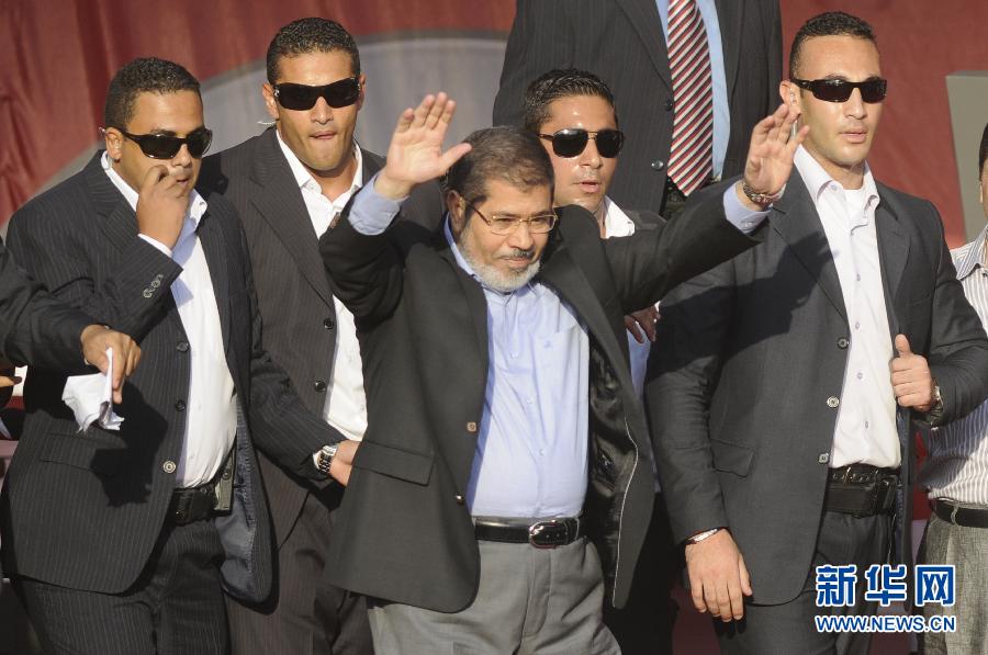 Mohamed Morsy (Mid), president of Egypt, waves to his supporters on the Tahrir Square in Cairo, Egypt, June 29, 2012.(Xinhua/AFP)