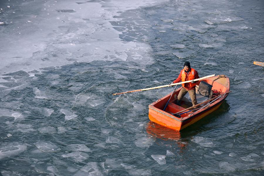 A worker tries to break ice blocks on the water in a spot scenery of Fenhe River in Taiyuan, north China's Shanxi Province, Jan. 5, 2013. Jan. 5 is the Slight Cold, the 23rd solar term according to the traditional Chinese lunar calendar, ushering in the coldest period in China. (Xinhua/Zhan Yan) 