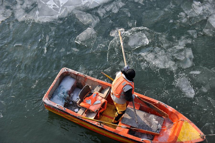 A worker tries to break ice blocks on the water in a spot scenery of Fenhe River in Taiyuan, north China's Shanxi Province, Jan. 5, 2013. Jan. 5 is the Slight Cold, the 23rd solar term according to the traditional Chinese lunar calendar, ushering in the coldest period in China. (Xinhua/Zhan Yan)  