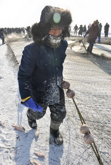 A fisherman dresses up warm to take part in a winter fishing event on Chagan Lake, Jilin province.(China Daily/Bai Shi)