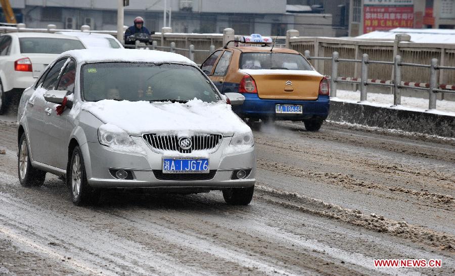 Vehicles run on a snow-affected main road in Changsha, central China's Hunan Province, Jan. 4, 2013. Changsha witnessed this winter's heaviest snowfall on Friday. The snow has caused disruption in the city's urban traffic. (Xinhua/Long Hongtao)