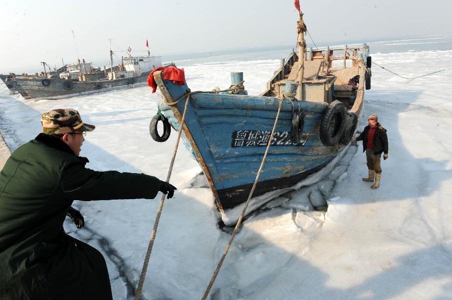 A fishing boat is stranded in the ice at Xidayang Fishing Wharf in Qingdao, east China's Shandong Province, Jan. 5, 2013. The ice conditions in the Bohai Sea and the Yellow Sea this January may be more serious than that in the past years, forecasted by North China Sea Marine Forecasting Center of State Oceanic Administration. (Xinhua/Li Ziheng)
