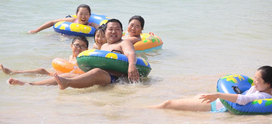 Tourists play in water at a beach in Sanya, a popular winter tourism destination in south China's Hainan Province, Jan. 5, 2013. (Xinhua/Chen Wenwu) 