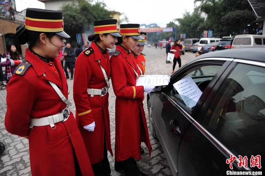 Staff in military uniforms distribute circulars to drivers, appealing people to comply with new traffic rules on Jan. 5, 2013. (Xinhua/Chen Chao)