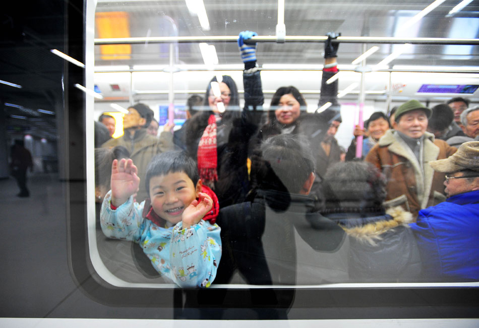 A boy looks through the window with a big smile on a train in Wuhan’s subway Line 2, Dec. 28, 2012. The line, which started operation on Dec. 28, is China's first subway to cross the Yangtze River. (Xinhua/Xiao Yijiu)