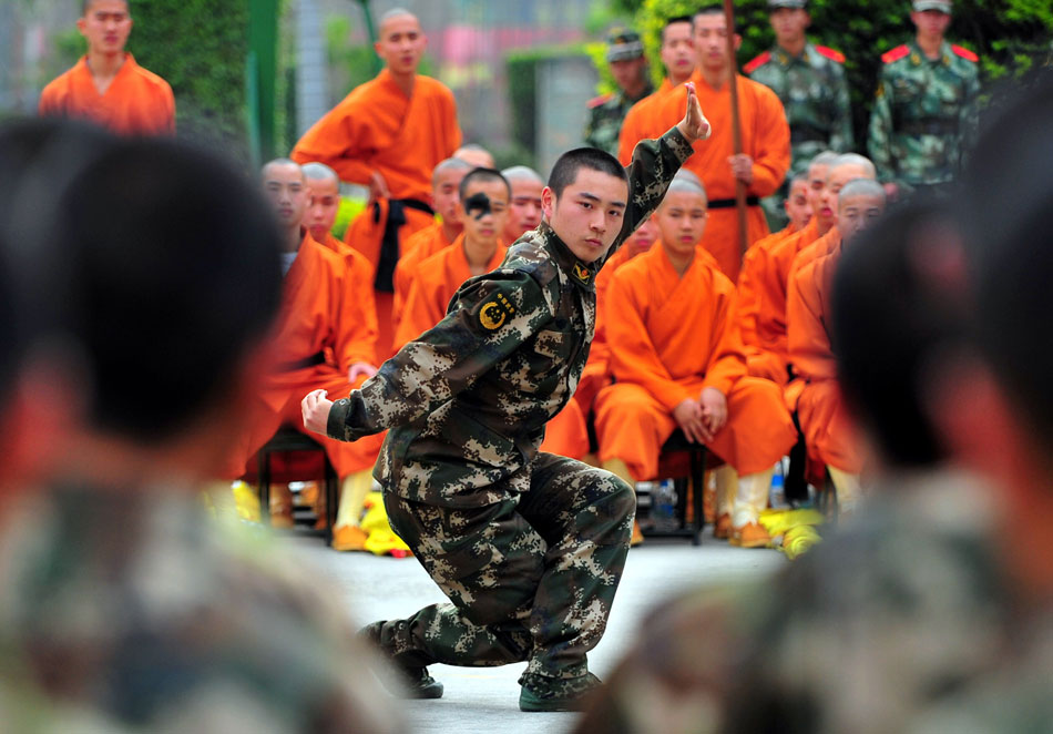 A soldier of frontier defense troop shows Chinese boxing in Quanzhou, Fujian province, Dec. 29, 2012. The troop invites 35 warrior-monks from Quanzhou’s Shaolin Temple to exchange kungfu and military skills with soldiers. (Xinhua/Wei Peiquan)