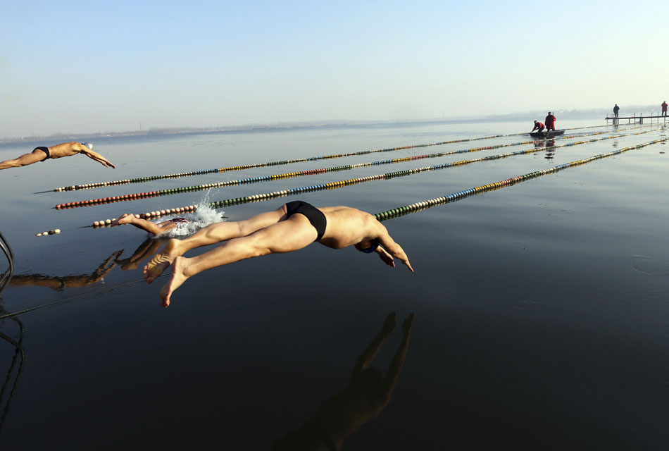 A swimmer jumps into freezing water during a winter swimming contest held to welcome the New Year in eastern China’s Huaibei city, Anhui province, Dec. 30, 2012. (Xinhua/Wan Shanchao)