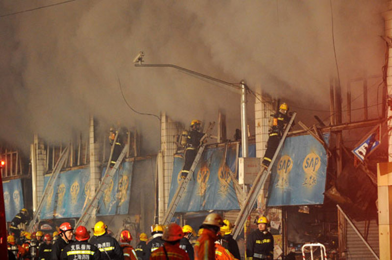 Firefighters try to put out fire at a farm produce wholesale market in Shanghai on Jan 6, 2013. (Photo/Xinhua) 