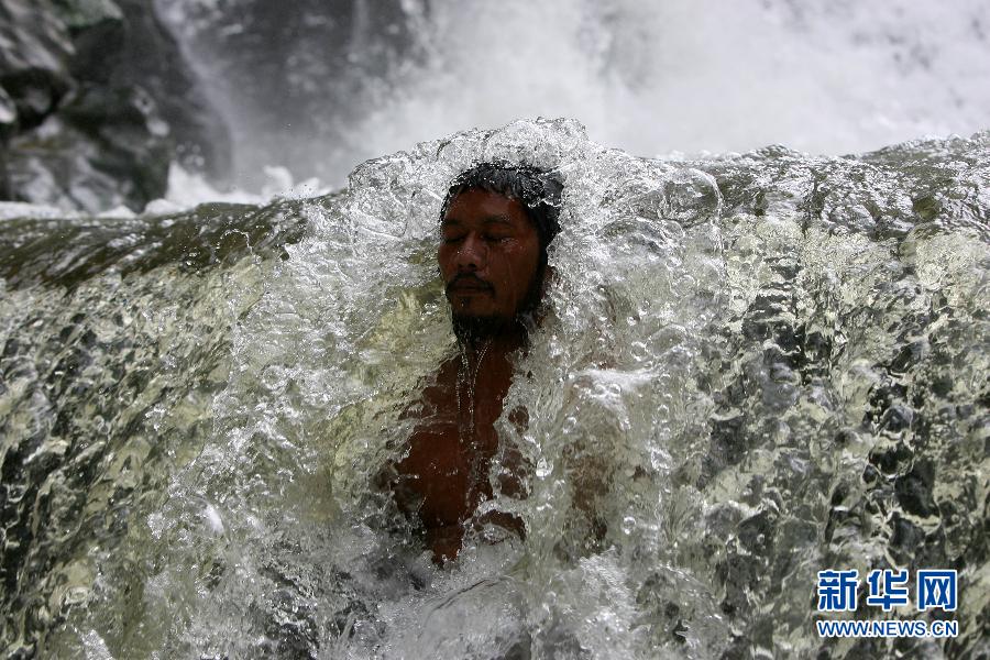 A man enjoys the waterfall of Wawa dam in Rizal Province, Philippines, March 18, 2012. (Xinhua, Rouelle Umali )