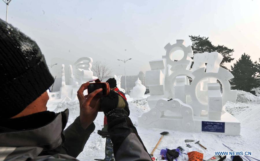 A college student takes photos of a creation by students from Harbin Normal University during the 5th International Snow Sculpture Contest for College Students in Harbin, capital of northeast China's Heilongjiang Province, Jan. 7, 2013. The contest, which attracted 58 teams from countries and regions including Britain, Japan, Russia, Thailand and the United States will come to an end soon. (Xinhua/Wang Song)  