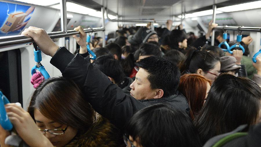 Commuters are pictured in a train of subway line 10, in Beijing, capital of China, Jan. 7, 2013. Subway line 10 has reached a daily transportation of 1 million passengers on average, just a week after Phase II's opening that completed a loop for former line 10. Subway line 10 is expected to become the busiest line in Beijing. (Xinhua/Wang Quanchao) 