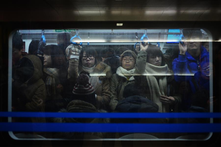 Commuters are pictured in a train of subway line 10, in Beijing, capital of China, Jan. 7, 2013. Subway line 10 has reached a daily transportation of 1 million passengers on average, just a week after Phase II's opening that completed a loop for former line 10. Subway line 10 is expected to become the busiest line in Beijing. (Xinhua/Wang Quanchao)