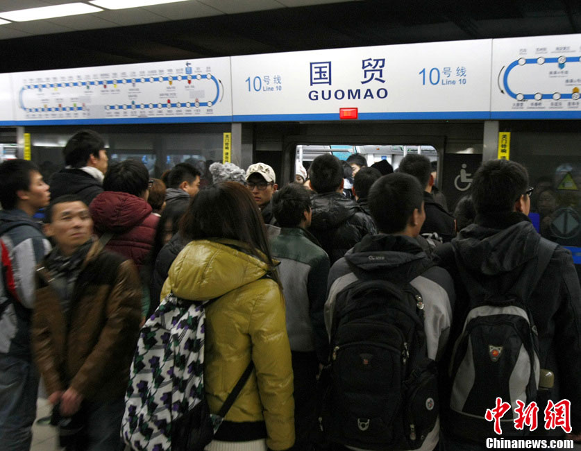 Commuters are pictured in a train of subway line 10 at the Guomao Station, in Beijing, capital of China, Jan. 7, 2013. Subway line 10 has reached a daily transportation of 1 million passengers on average, just a week after Phase II's opening that completed a loop for former line 10. Subway line 10 is expected to become the busiest line in Beijing. (Xinhua/Wang Quanchao)