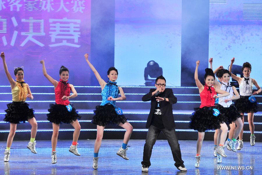 Girls perform with a performer in the final of the 5th World Hakka Girl Contest in Meizhou, south China's Guangdong Province, Jan. 6, 2013. (Xinhua/Zhong Xiaofeng)