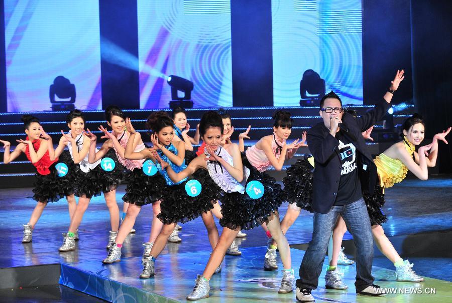 Girls perform with a performer in the final of the 5th World Hakka Girl Contest in Meizhou, south China's Guangdong Province, Jan. 6, 2013. (Xinhua/Zhong Xiaofeng)