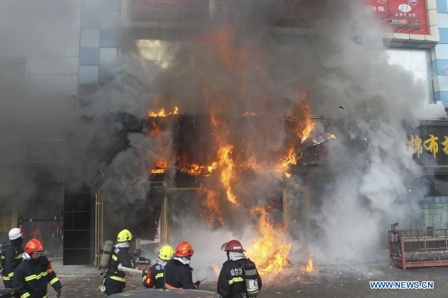 Firemen work to put out fire in a shopping mall in Harbin, capital of northeast China's Heilongjiang Province, Jan. 7, 2012. Casualty information is unknown yet after the fire started at around 9 a.m. (0100 GMT) in the Guorun Home Textiles Shopping Mall in downtown Harbin on Monday. The fire consumed an area of 9,400 square meters over the course of three and a half hours before being stopped. Firefighters helped evacuate shoppers from the five-story building. (Xinhua/Xiao Jinbiao) 