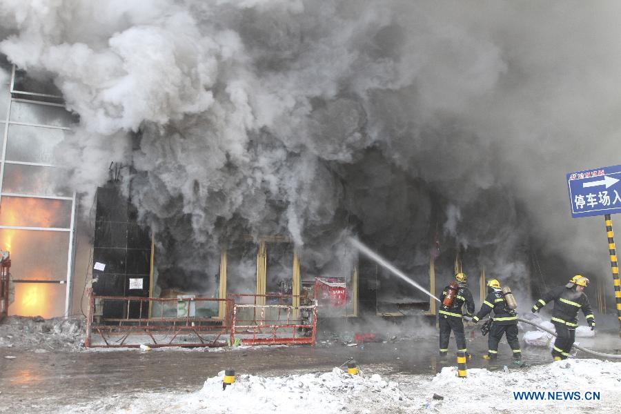 Firemen work to put out fire in a shopping mall in Harbin, capital of northeast China's Heilongjiang Province, Jan. 7, 2012. Casualty information is unknown yet after the fire started at around 9 a.m. (0100 GMT) in the Guorun Home Textiles Shopping Mall in downtown Harbin on Monday. The fire consumed an area of 9,400 square meters over the course of three and a half hours before being stopped. Firefighters helped evacuate shoppers from the five-story building. (Xinhua/Xiao Jinbiao) 