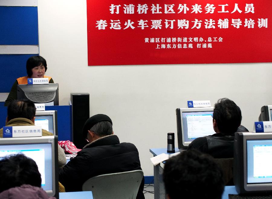 Working staff help migrant workers buy tickets on line in east China's Shanghai Municipality, Jan. 7, 2013. The tickets for the upcoming Spring Festival rush period can be purchased via online and phone-call booking systems since Jan. 7. Shanghai railway administration provided group ticket-purchasing service for migrant workers in Shanghai. The Spring Festival for family reunions begins from the first day of the first month of the traditional Chinese lunar calendar, or Feb. 10, 2013. (Xinhua/Chen Fei)