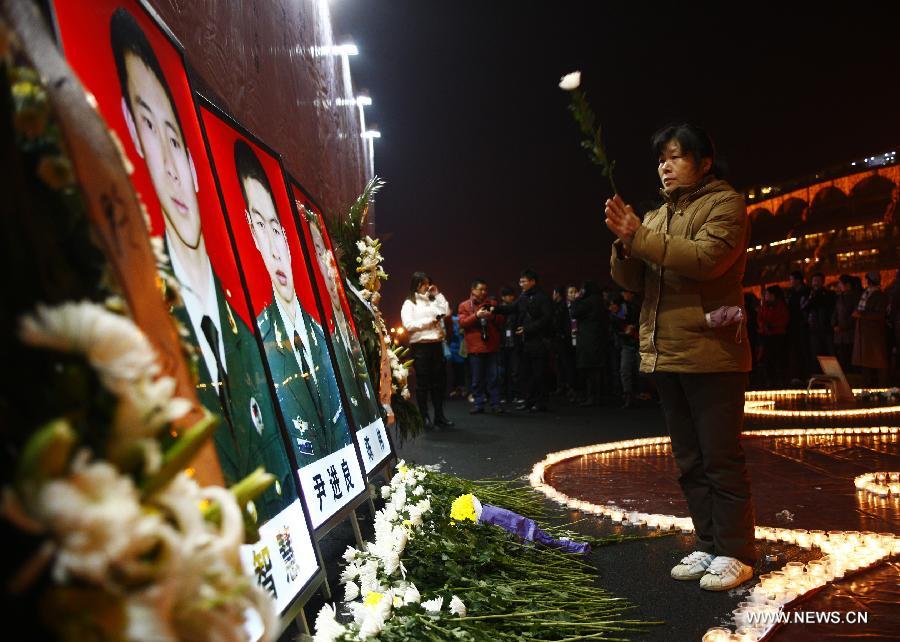 A woman mourns the three firefighters who died while putting out fire in a factory blaze, during a memorial service for the three firefighters who died while putting out fire in a factory blaze, at the Wushan Square in Hangzhou, capital of east China's Zhejiang Province, Jan. 7, 2013. Local citizens gathered here on Monday evening to mourn the three firefighters who sacrificed their lives while putting out a fire in Hangzhou's Xiaoshan District, six days after the fire broke out. The three firefighters, Yin Jinliang, Chen Wei and Yin Zhihui, were ratified as martyrs and awarded gold medals for their dedication to the national defence. They were also personally awarded the top-grade merit citation. (Xinhua/Cui Xinyu) 