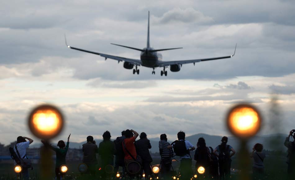Many people use their cameras to record the last moment of Wujiaba airport in Kunming on June 26, 2012. At 10 p.m., the last airplane took off, which marked the Kunming Wujiaba International Airport quit the stage of history. (Xinhua)