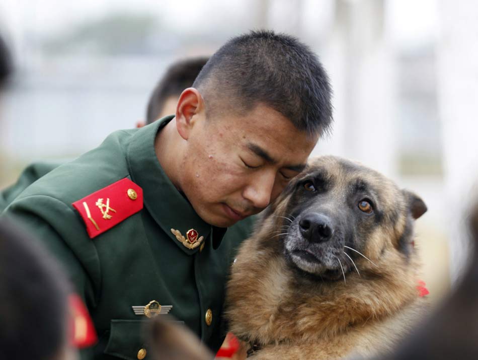Dog trainer from Jiangsu Armed Police Corps bid farewell to the patrol dog after service on Nov. 23, 2012. (Xinhua/Li Ke)