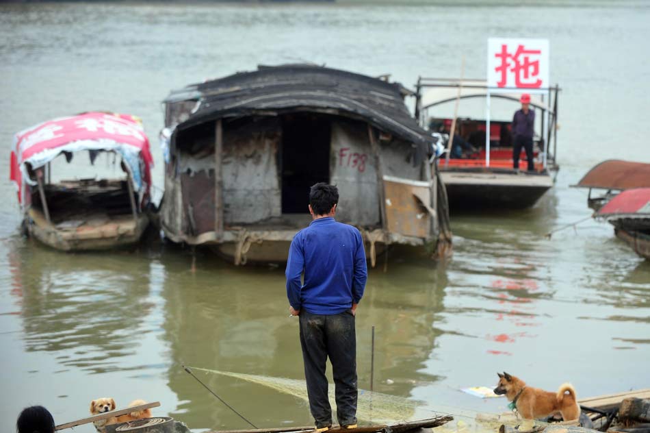 Tug tows away Luo Guishun's fishing boat on Nov. 24, 2012. Luo Guishui nearly 50 years old, grew up in boat and made living by fishing for decades in Nanning of Guangxi. To comply with the new municipal planning of Nanning government, Luo signed the settlement agreement with the government and decided to move from the Yijiang River to downtown. "I didn't receive education and I am old, who will offer me a job?" Luo was full of worries about the future life on shore.(Xinhua)