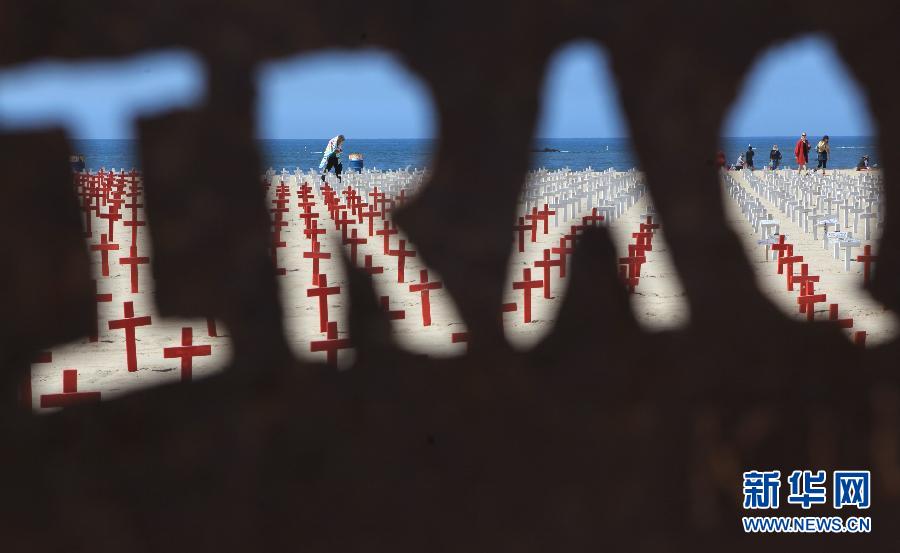 People visit a temporary cemetery, known as "Arlington West", on the beach of Santa Monica, in California, the United States, on April 16, 2012. The temporary cemetery, "Arlington West", was named after the national cemetery of the United States, Arlington National Cemetery, a burial place of honor for fallen war heroes. Arlington West was established for the soldiers who died in the Afghanistan War and Iraq War by American anti-war activists. People erect the crosses here every Sunday as many as the soldier died in the two wars. (Xinhua/Liu Yu) 