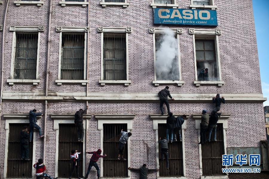 Protestors try to put out fire in a civilian building near Ministry of Interior building in Cairo, Egypt, Feb. 3, 2012. At least four people were killed and 1,482 were injured in the clashes between security forces and protestors in Egypt on Feb. 2 and Feb. 3, 2012. (Xinhua/Li Muzi) 