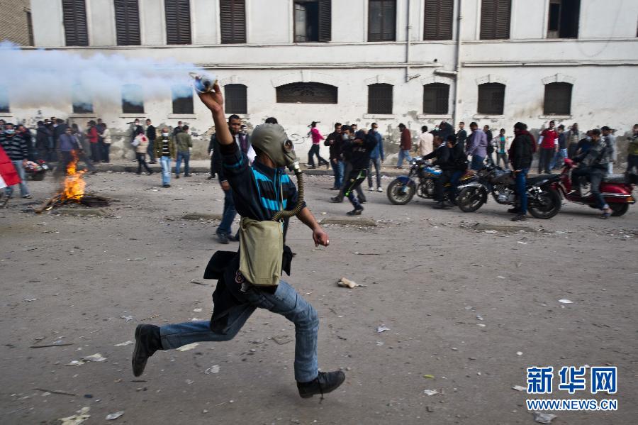 A protestor tries to throw back teargas shell fired by the police near Ministry of Interior building in Cairo, Egypt, Feb. 3, 2012. At least four people were killed and 1,482 were injured in the clashes between security forces and protestors in Egypt on Feb.2 and Feb. 3, 2012. (Xinhua/Li Muzi) 