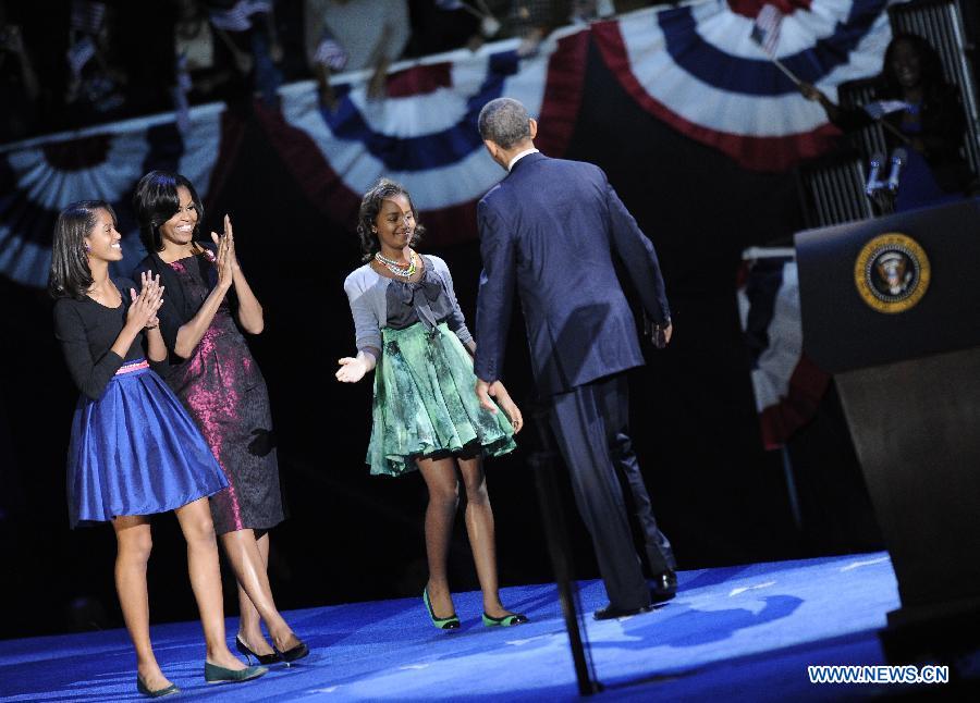 U.S. President Barack Obama walks to his wife Michelle Obama and daughters Sasha and Malia during his election night victory rally in Chicago, the United States, on Nov. 7, 2012. (Zhang Jun)