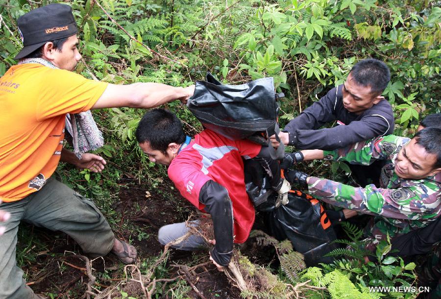 Rescuers carry the body of a plane crash victim at the site where the Russian-made Sukhoi super jet-100 crashed in the Mount Salak in Bogor, West Java, Indonesia, May 11, 2012. (Xinhua/Veri Sanovri)