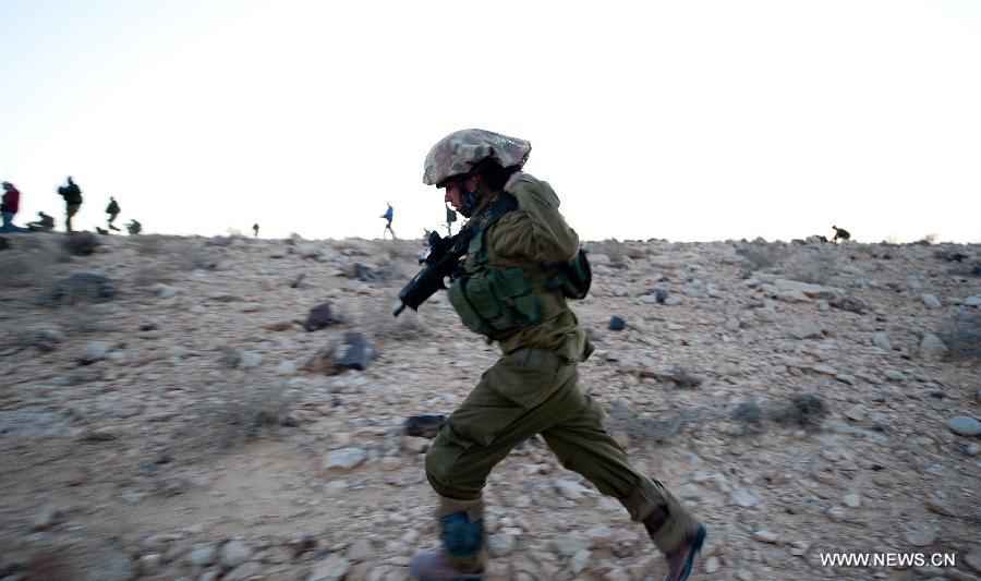 An Israeli woman soldier takes part in a military drill at the western part of Sede Boqer, southern Israel, on Dec. 13, 2012. (Xinhua/Yin Dongxun)