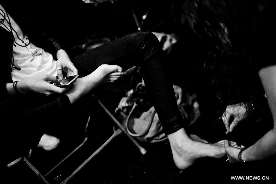 A model uses her mobile phone backstage during the Vivienne Tam Spring/Summer 2013 collection show at New York Fashion Week in New York, the United States, Sept. 12, 2012. (Xinhua/Shen Hong) 