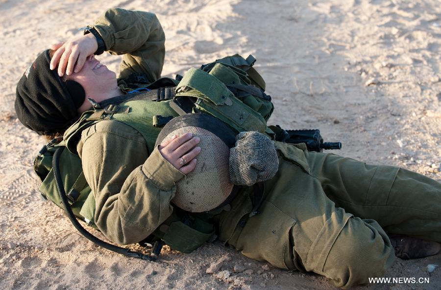 An Israeli woman soldier takes a rest during a military drill at the western part of Sede Boqer, southern Israel, on Dec. 13, 2012. (Xinhua/Yin Dongxun)