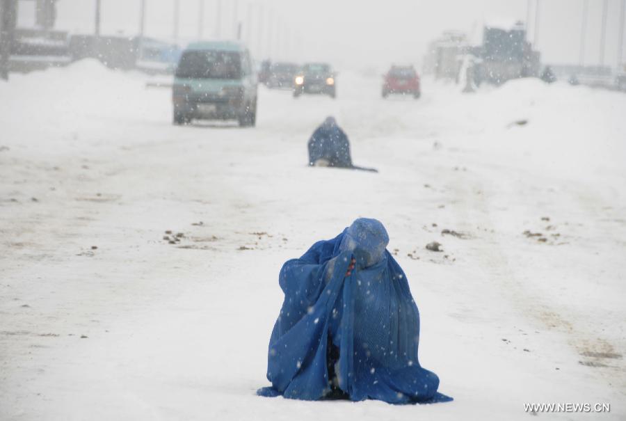 An Afghan woman begs on a road in a heavy snowfall in Kabul, capital of Afghanistan, on Feb. 3, 2012. Unprecedentedly in couple of years, a chilly winter, accompanied by heavy snowfalls, hit most parts of the mountainous Afghanistan. (Xinhua/Ahmad Massoud) 