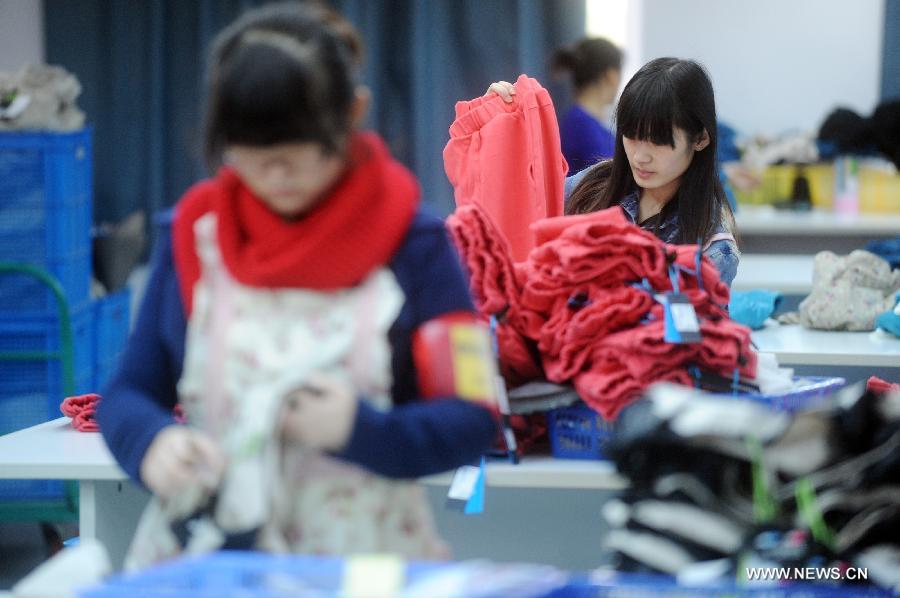 Photo taken on Nov. 11, 2012 shows staff members sorting out the clothes for delivery at the Hangzhou 7gege Company, an online store at Taobao.com in Hangzhou, capital of east China's Zhejiang Province. (Xinhua/Huang Zongzhi) 