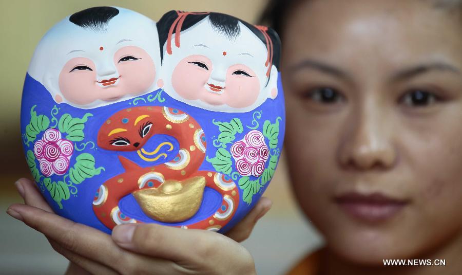 An artisan shows the traditional Chinese clay sculptures designed with the snake image in Sanya City, south China's Hainan Province, Jan. 8, 2013. The lunar year 2013 is the "Year of the Snake" in the Chinese zodiac. (Xinhua/Chen Wenwu)
